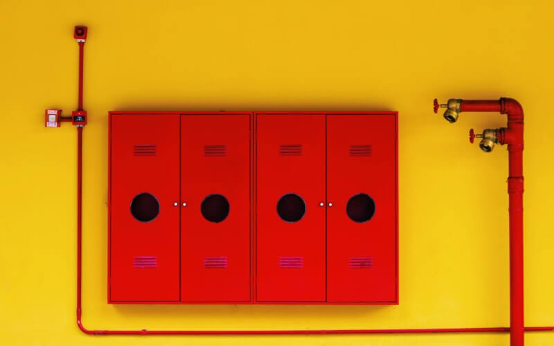 Red water pipes on a yellow wall - striking color contrast