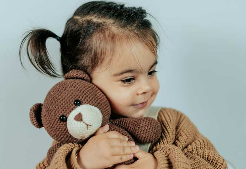 Baby Girl holding a Toy Image