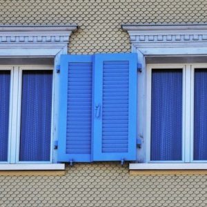 Blue curtains on windows with blue shutters