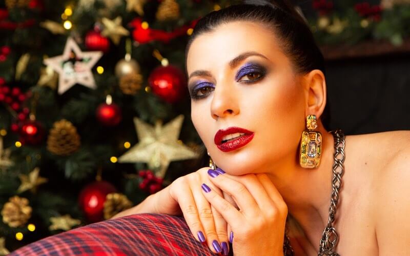 Woman wearing makeup with a Christmas tree in the background