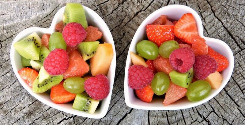 Heart shaped bowls with cut fruits pieces ready to serve