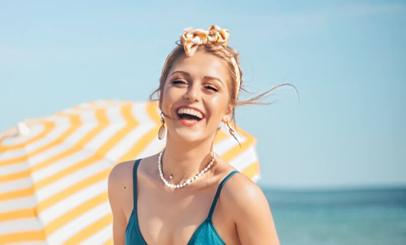 Woman smiling and laughing at a beach in summer