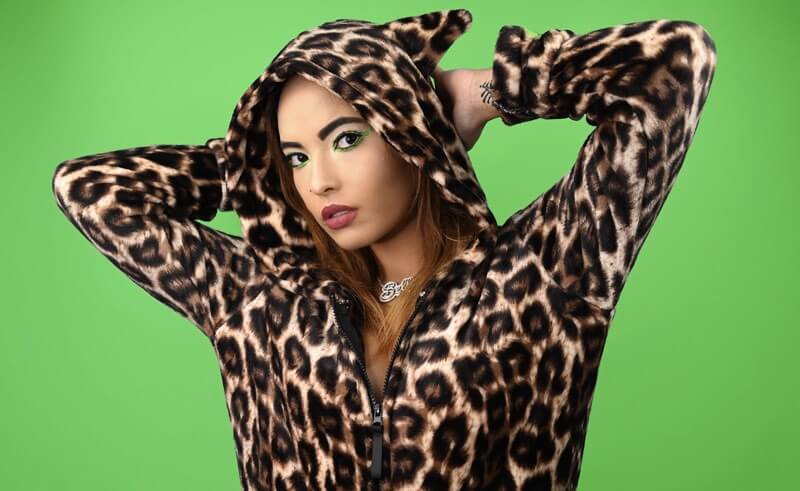 Woman wearing a leopard print hoodie on a green background