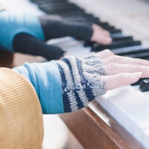 Hands playing the piano on a winter day