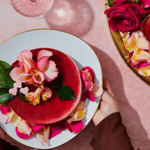 Woman holding a Red Cake with Flowers - Image